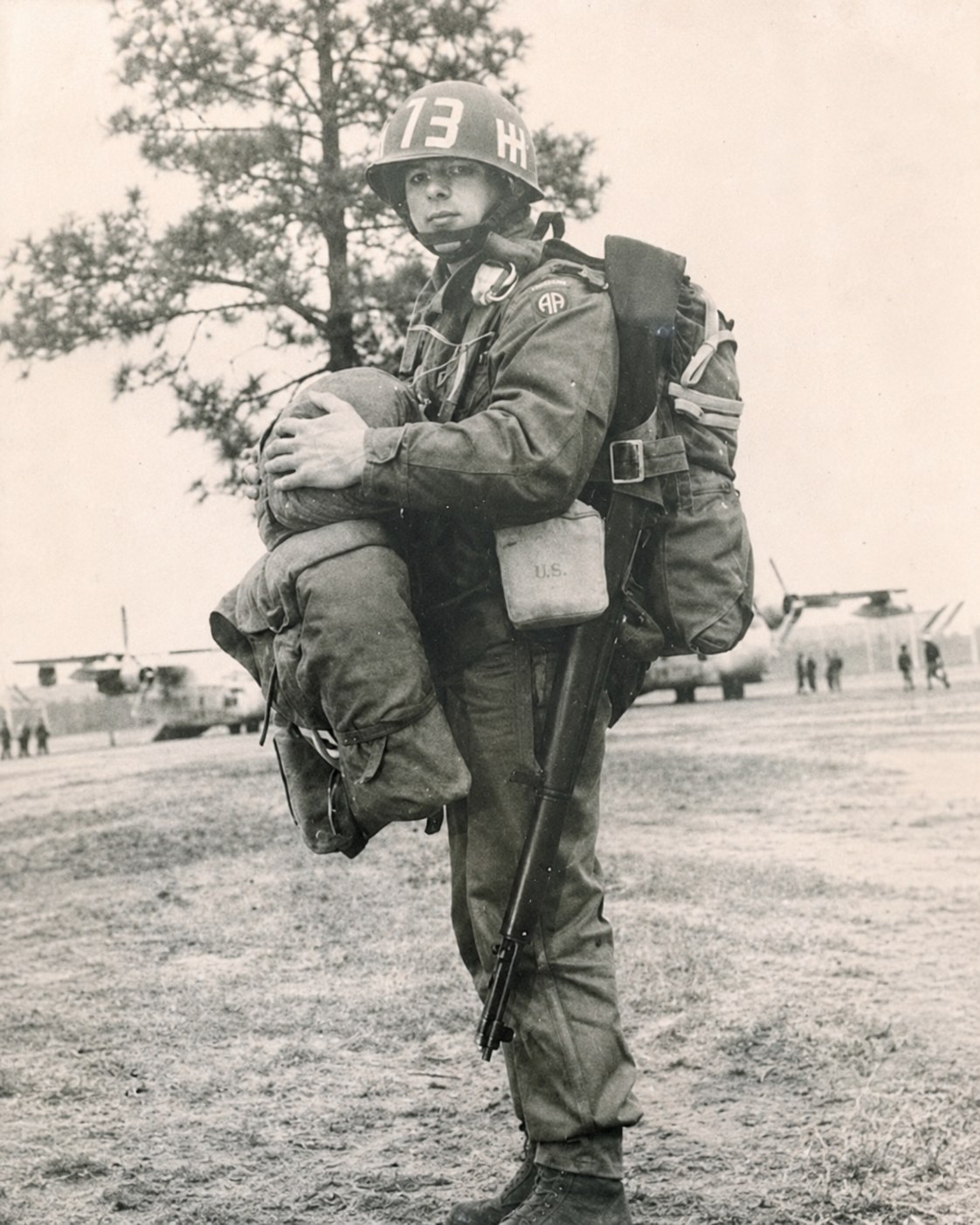 George Shave Jr. in his 82nd Airborne paratrooper uniform, standing on an airfield
